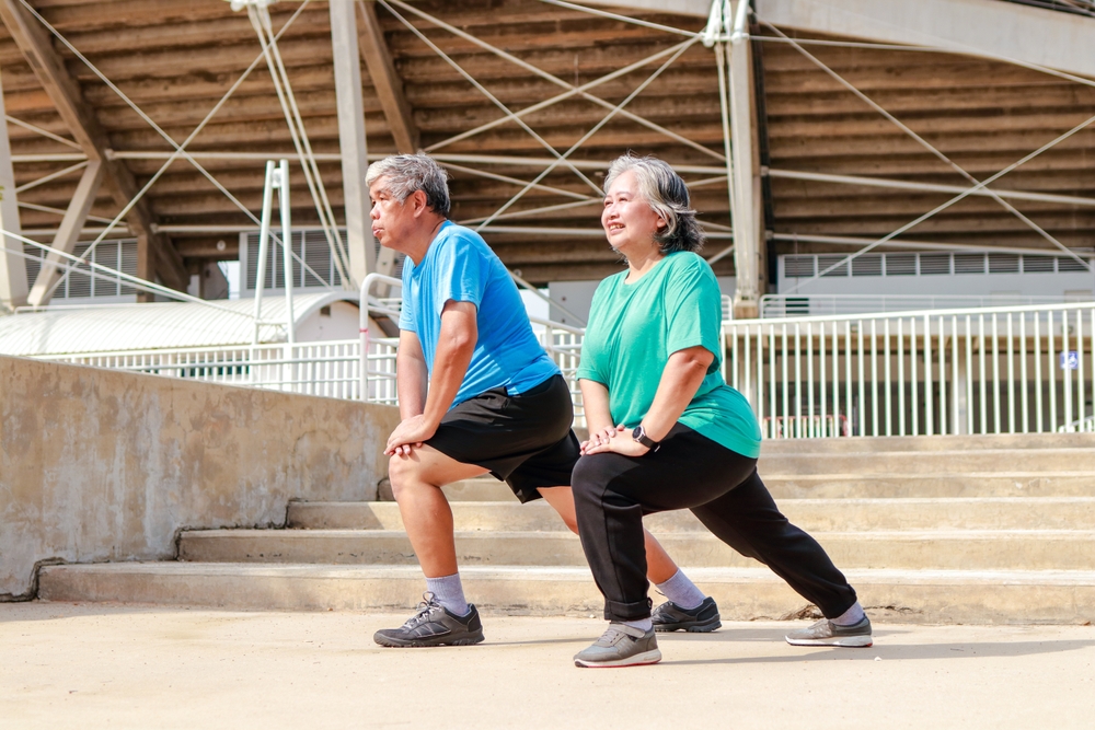Asian elderly couple exercising outdoors